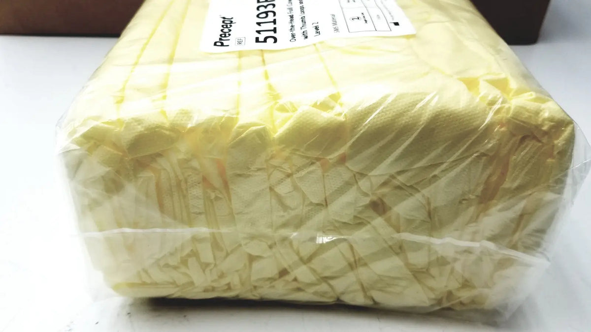 A package of pale yellow crinkled tissue paper wrapped in clear plastic with a white label for count precept medical gowns