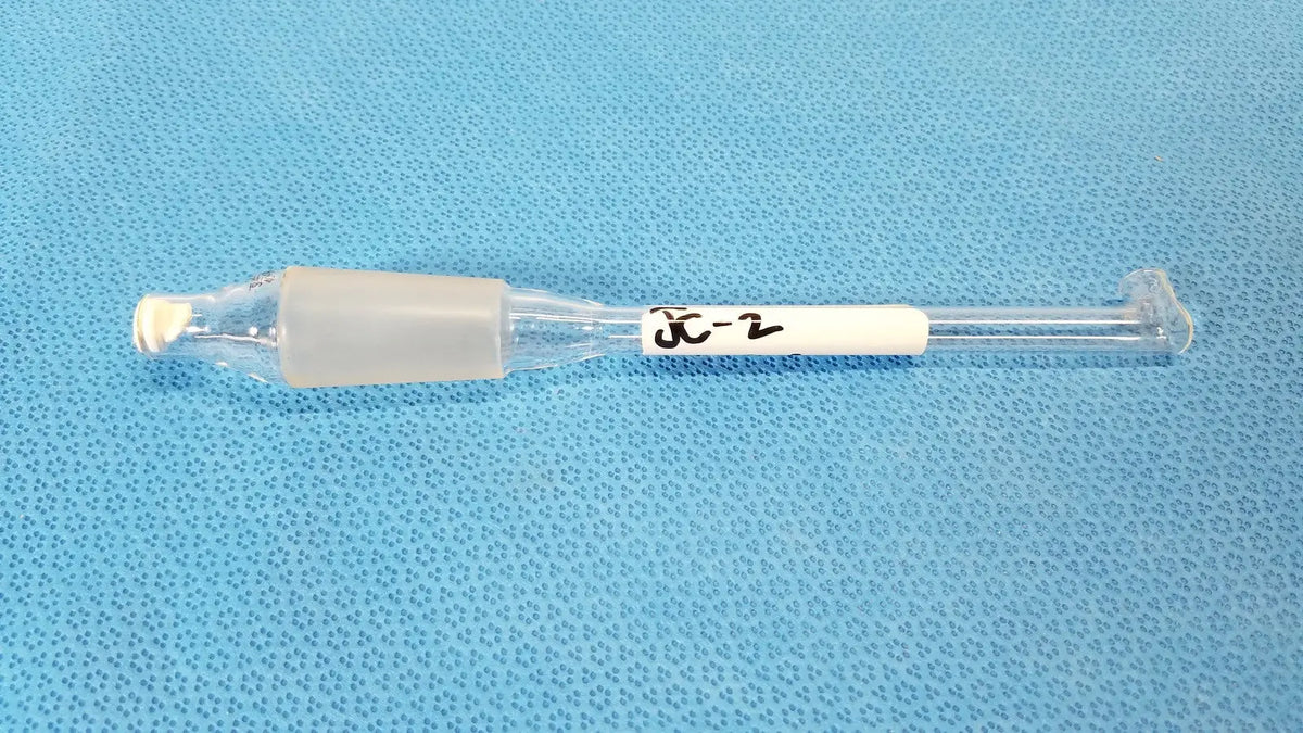 Clear glass thermometer adapter with translucent gray plastic cap and white label marked x-2 for lab thermometry use
