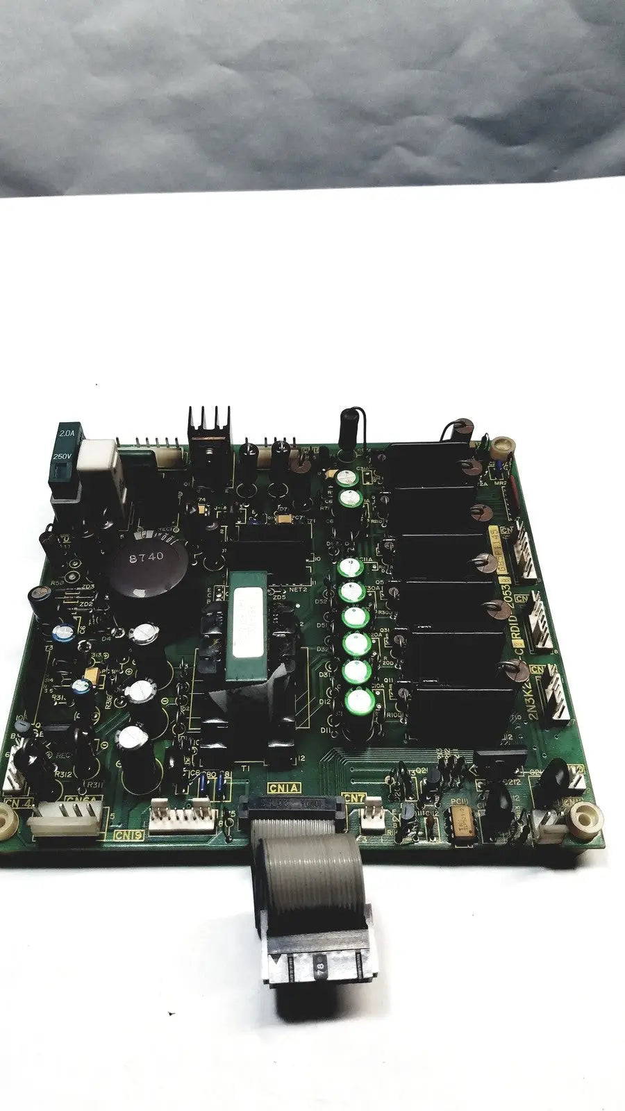 Green printed circuit board with black components white capacitors and a coiled gray cable on 2p8414t mother board