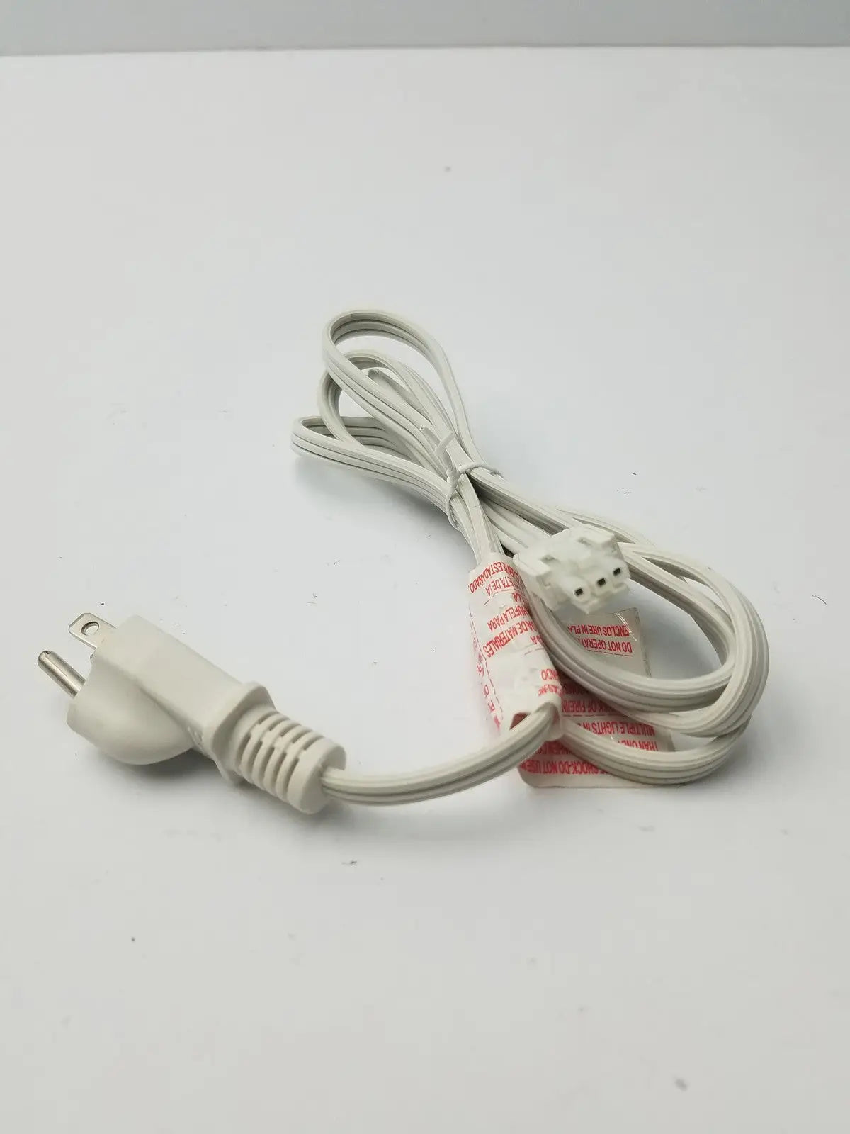 White 3 prong to 3 pin female power extension cord with two prong plug coiled neatly on a plain surface