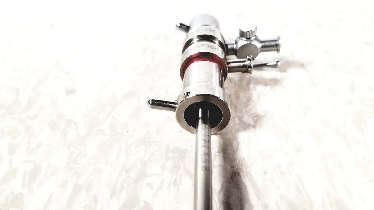 Silver 3M 83272 pressure dispensing cannula with red band and engraved markings featuring rotating stopcocks
