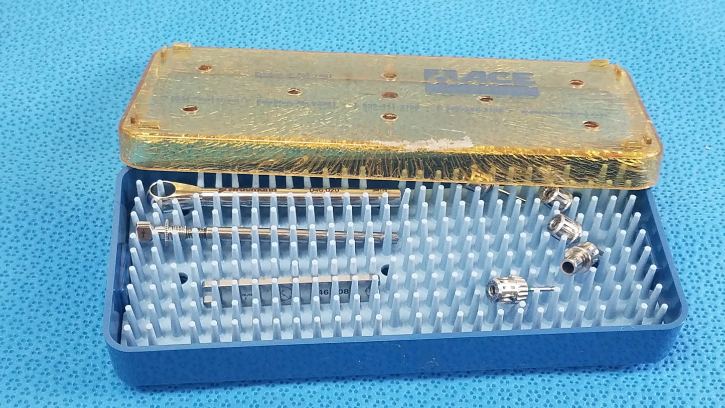 Blue plastic sterilization tray with gold lid containing organized metal dental implant instruments and components for medical equipment