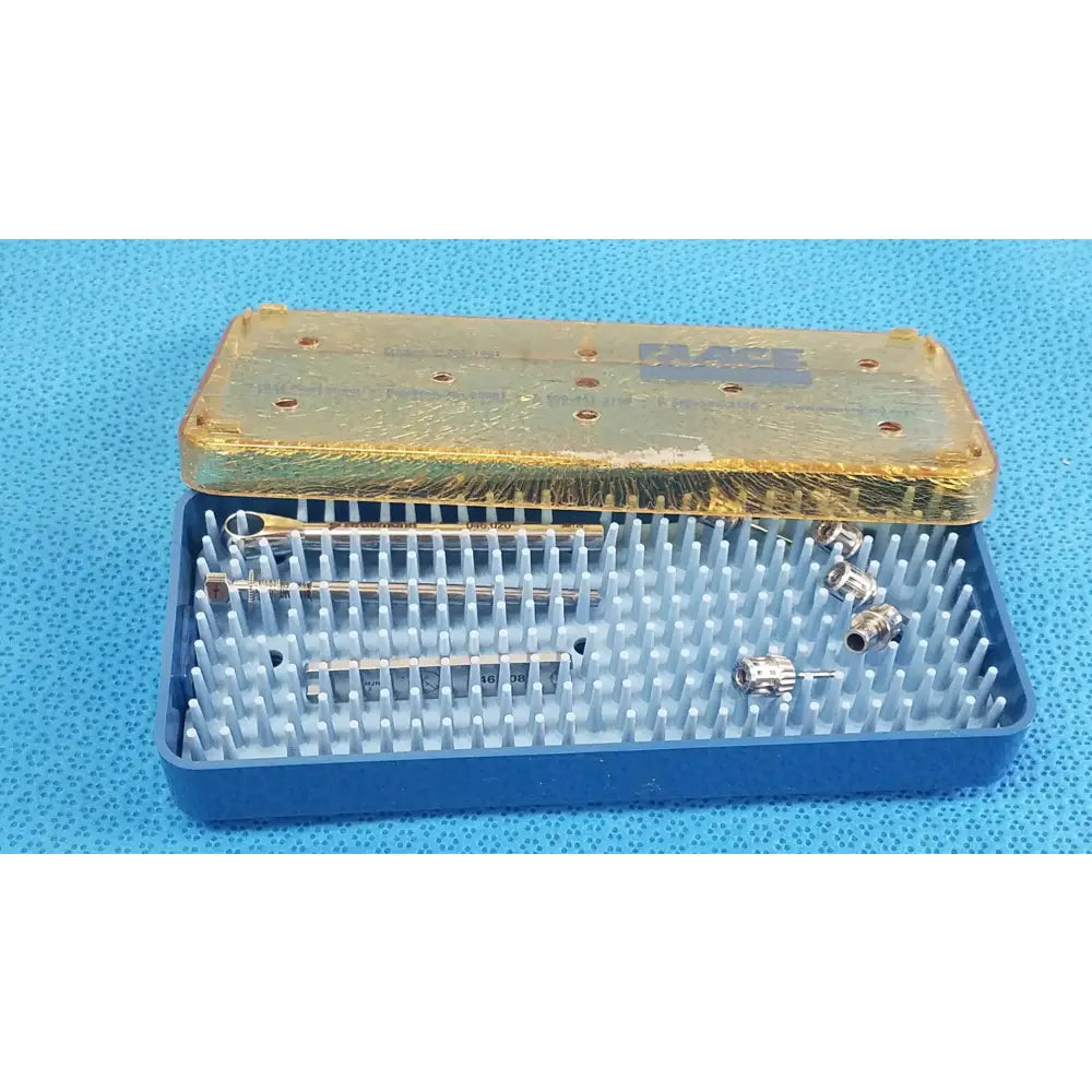 Blue plastic sterilization tray with gold lid containing organized metal dental implant instruments and components for medical equipment