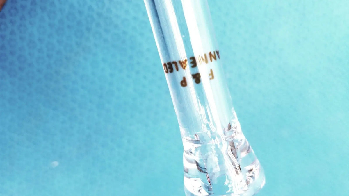Clear glass test tube with gold engraved text f&p annealed containing clear liquid paired with ace glass straight bore stopcock adapter