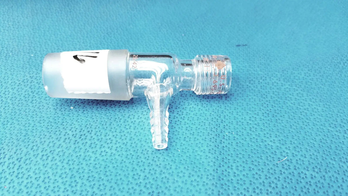 Clear glass lab glass fitting thermometer adapter with frosted white cap and threaded connections for lab use
