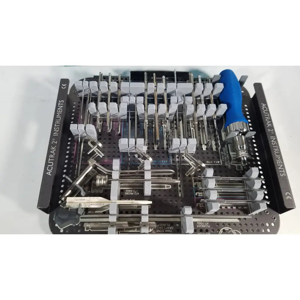 Black metal surgical instrument tray with organized stainless steel tools and blue-handled screwdriver for Acutrak 2 headless compression screw system reuse medical use