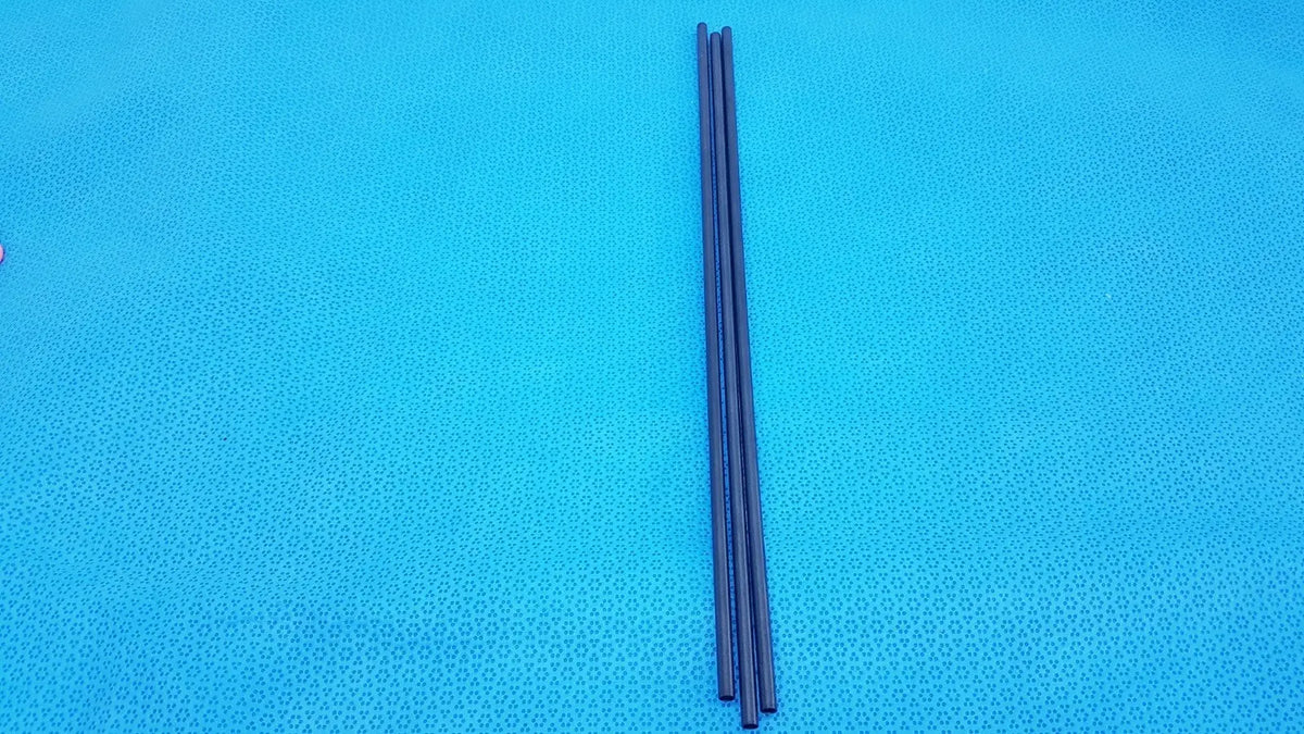 Three slender black aesculap pm973r insulated outer tubes 5 x 310 mm lie parallel on a bright blue textured surface