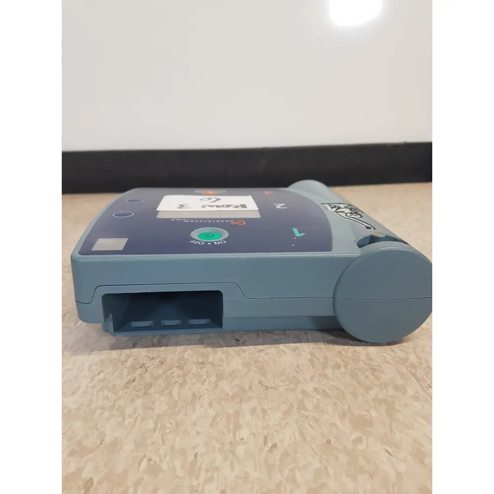 Blue-gray agilent heartstream fr2 semi automatic patient monitor showing green power button and labeled ports