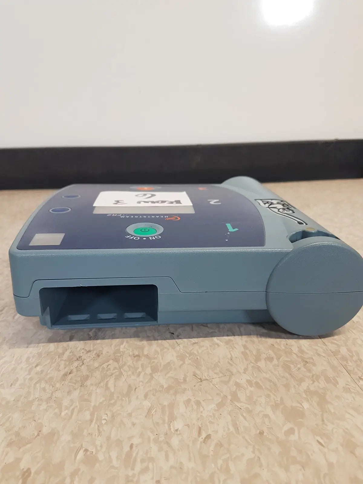 Blue-gray agilent heartstream fr2 semi automatic patient monitor showing green power button and labeled ports
