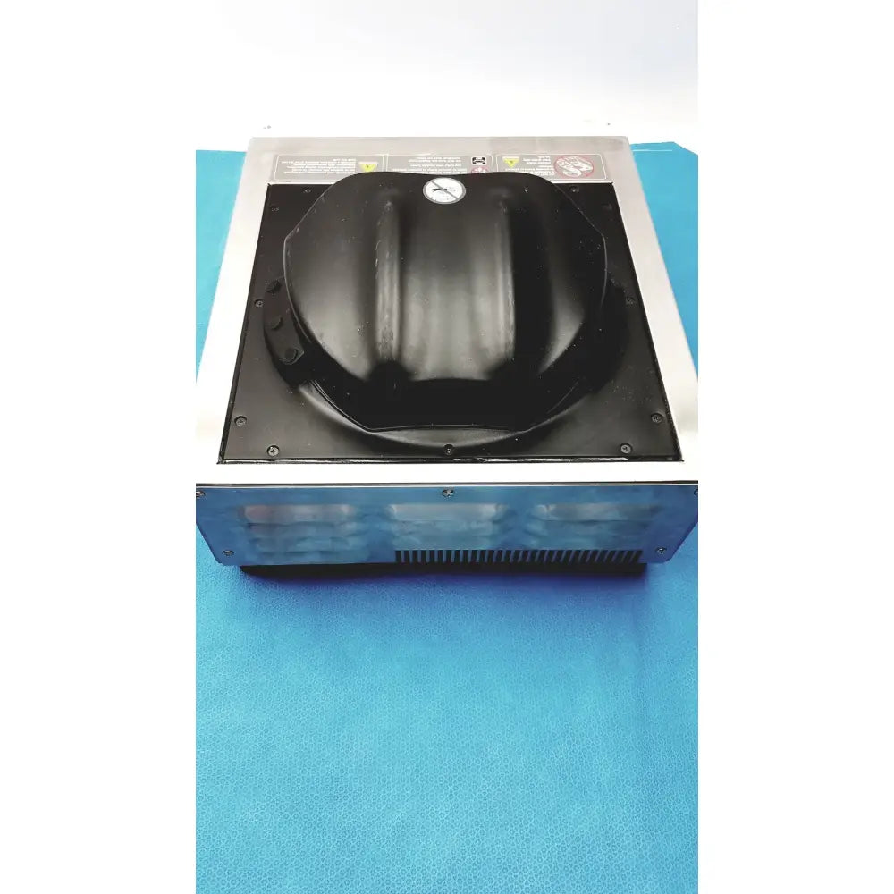 Black plastic dome-shaped lid with emblem on metallic frame of aladdin temp-rite heat on demand advantage plate heater