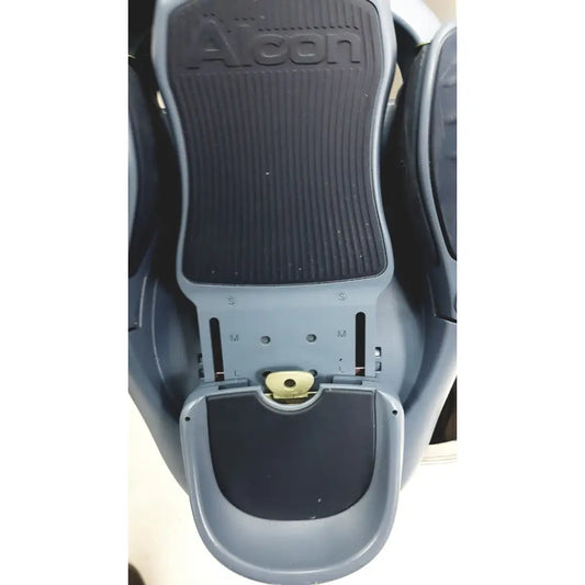 Gray Alcon Infiniti Vision system footrest with black textured rubber pads and adjustable sizing markings