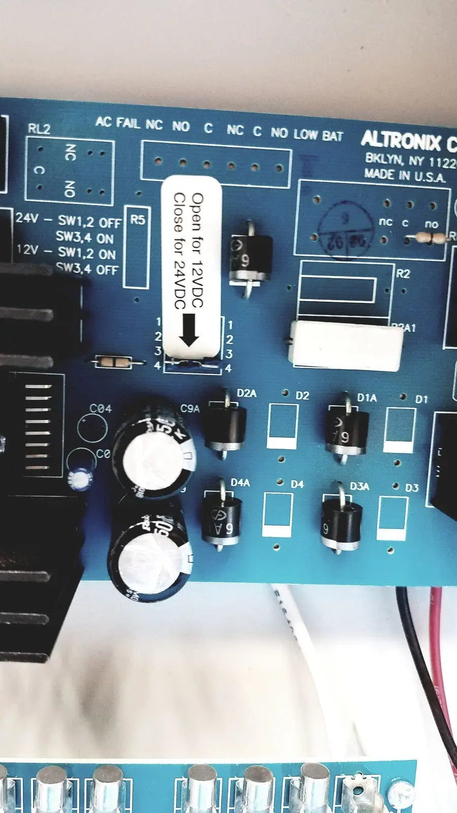 Blue altronix smp5ctx high current power supply circuit board with black and white electronic components visible