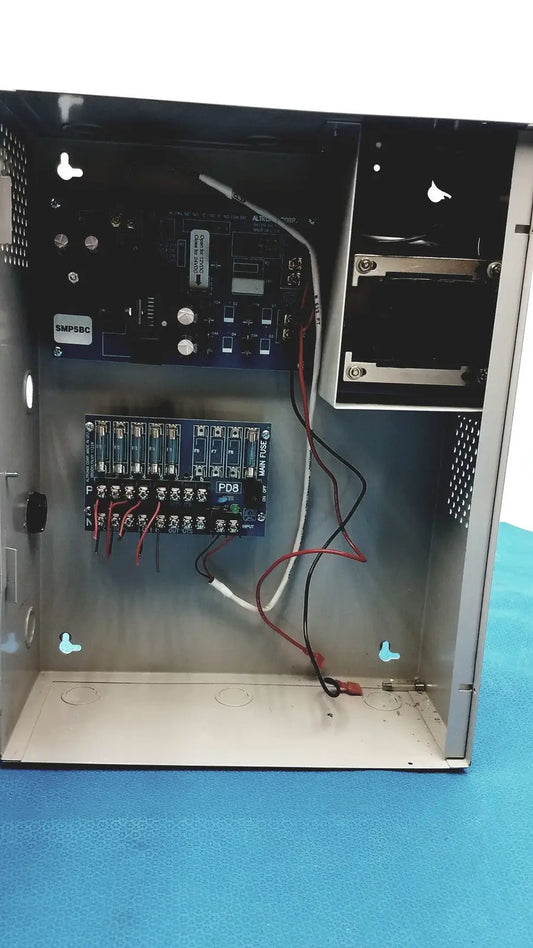 Black metal altronix smp5ctx power supply with visible internal circuit boards and wiring for 12vdc or 24vdc use