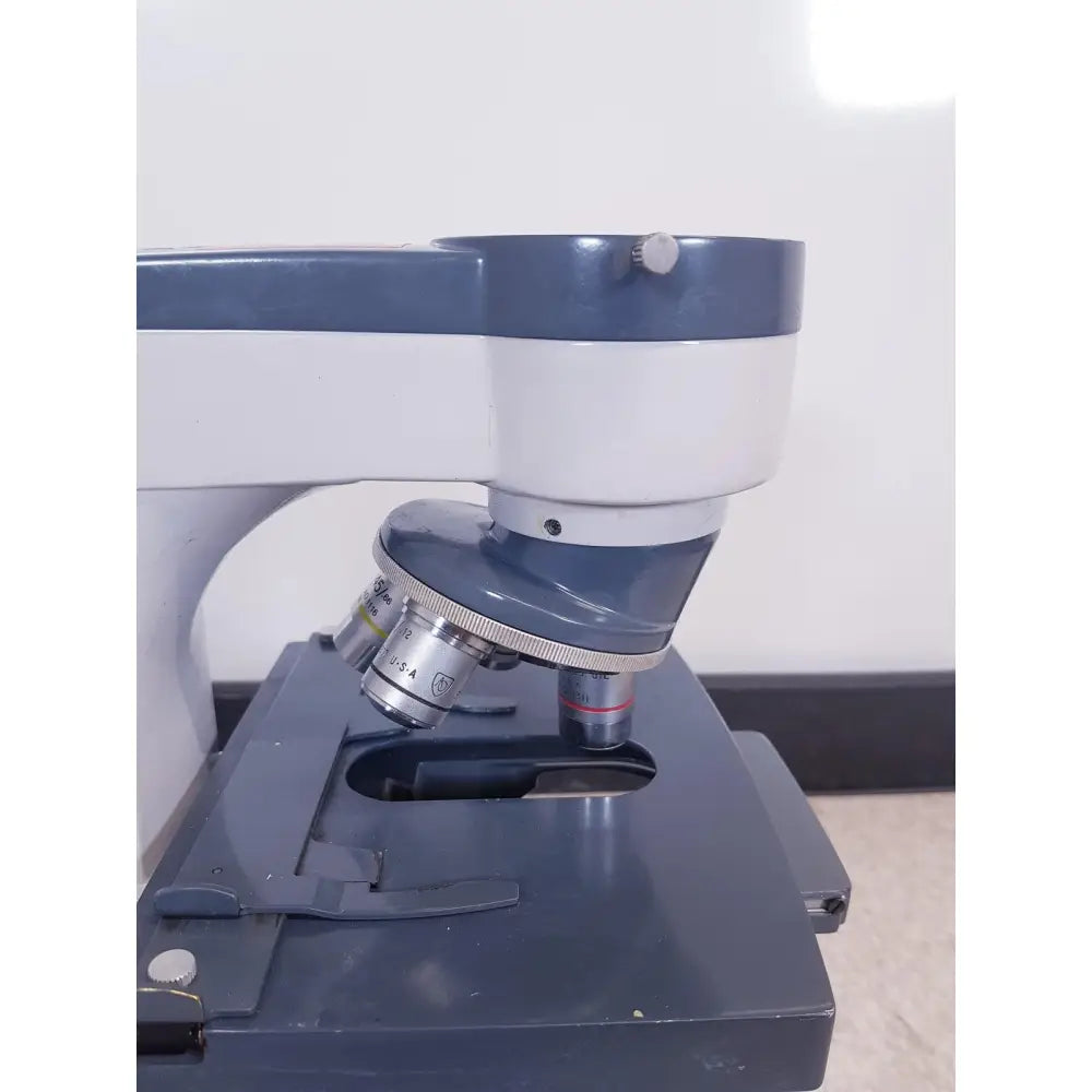 Gray and white compound microscope with metallic objective lenses for scientific instruments one-ten illuminator model 1130a