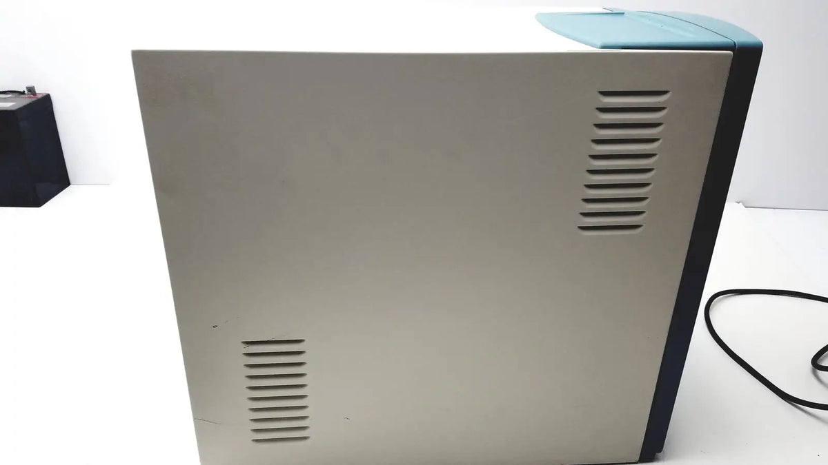 Beige and teal desktop printer with vertical ventilation slits on sides showing back view applied precision introduces arrayworxe biochip reader