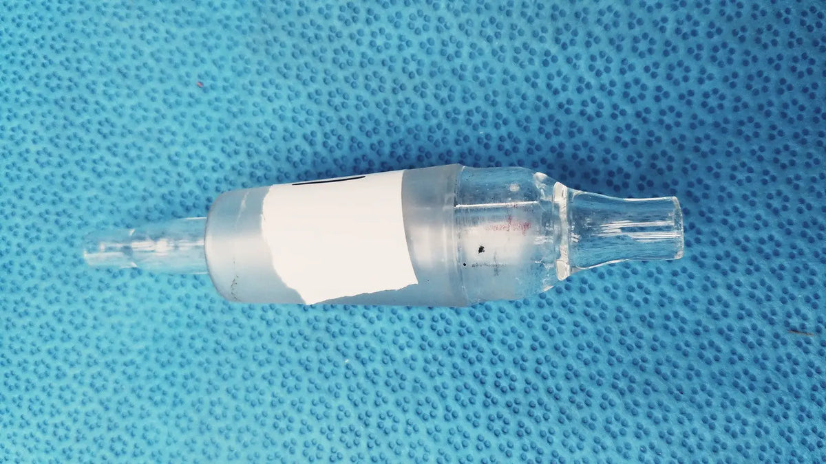 Clear glass aquarium air pump control valve with white label wrapped around midsection for pump control use