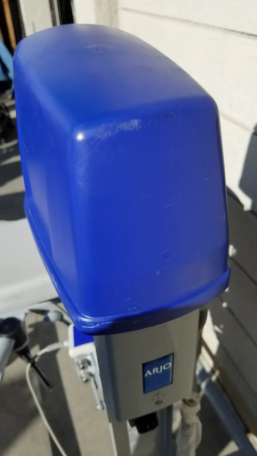 Blue plastic cover on the arjo huntleigh power electric walker lift for ambulatory support medical use