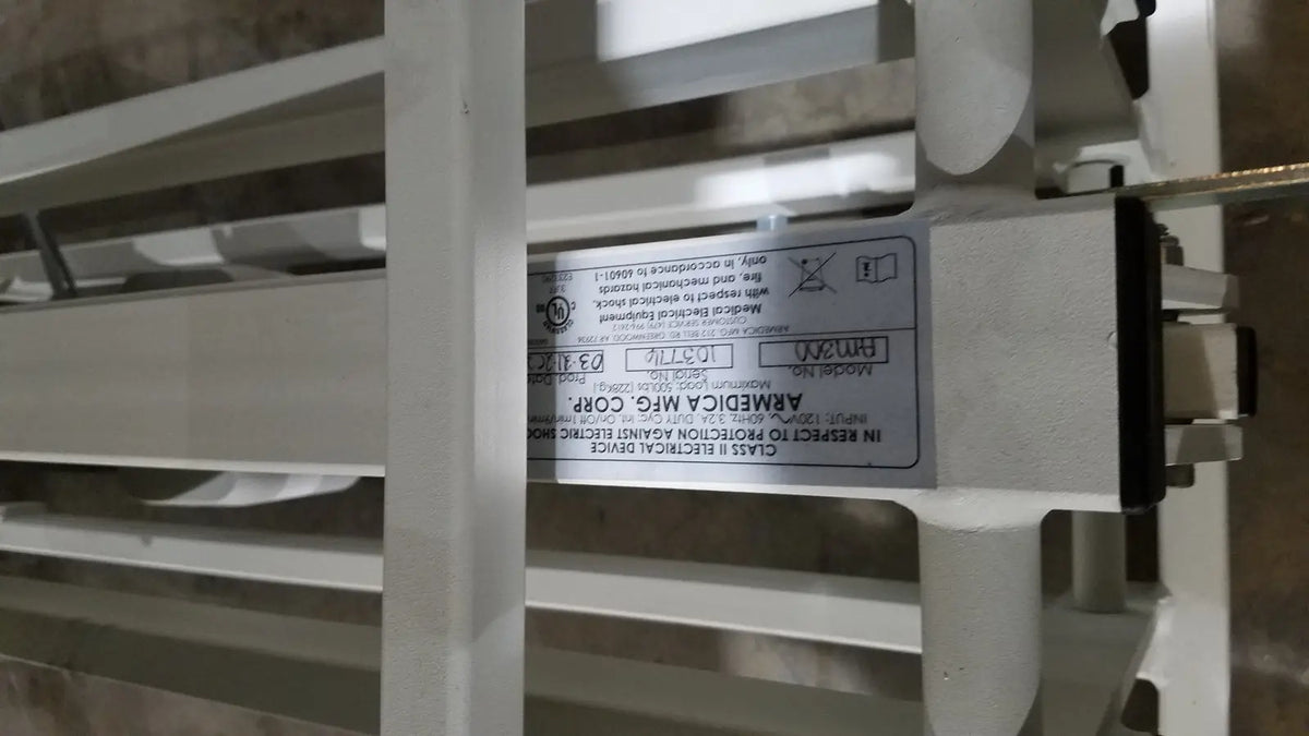 White label with black text on the back of an Armedica AM-300 three section treatment table electrical component