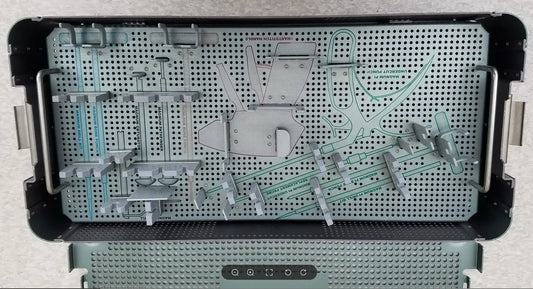 Silver metal sterilization tray with perforated surface and compartments holding orthopedic tools from autocuff opus collection