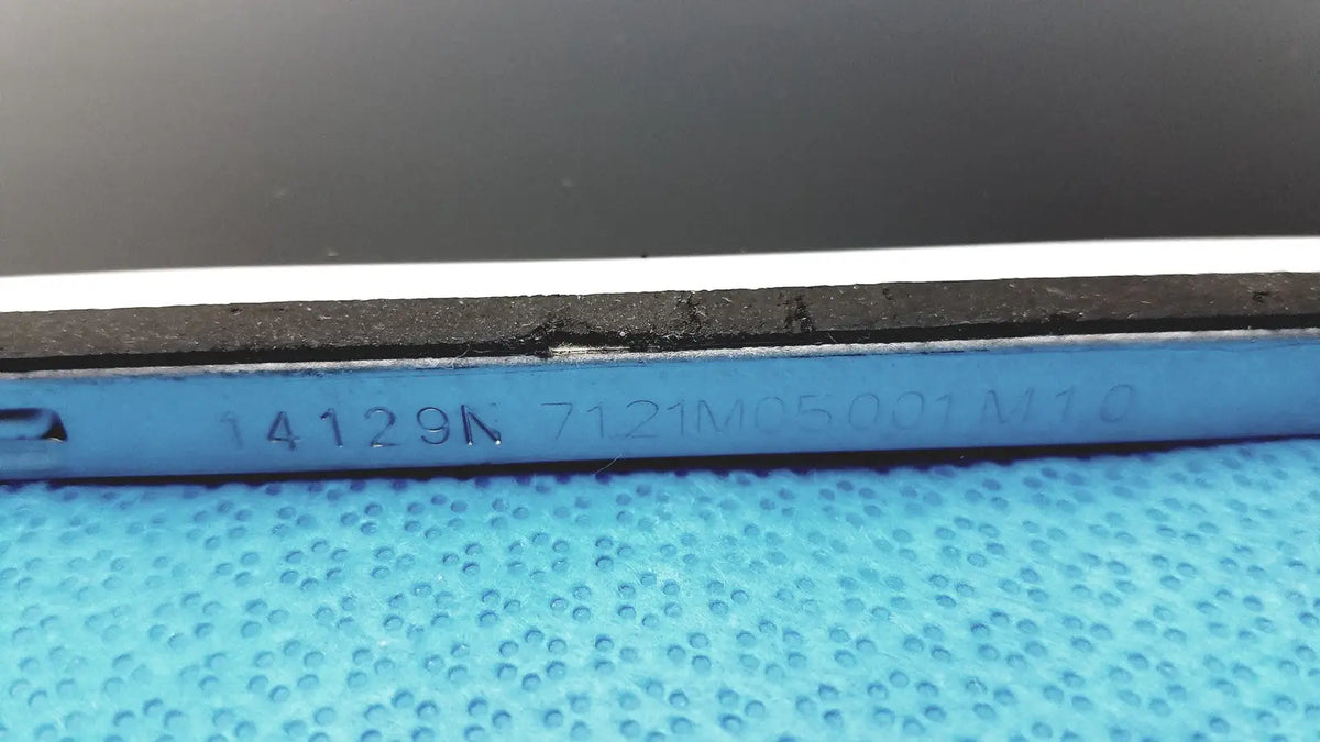 Blue plastic tool with engraved serial numbers and black rubberized edge on the back of auo m215htn01 lcd screen panel