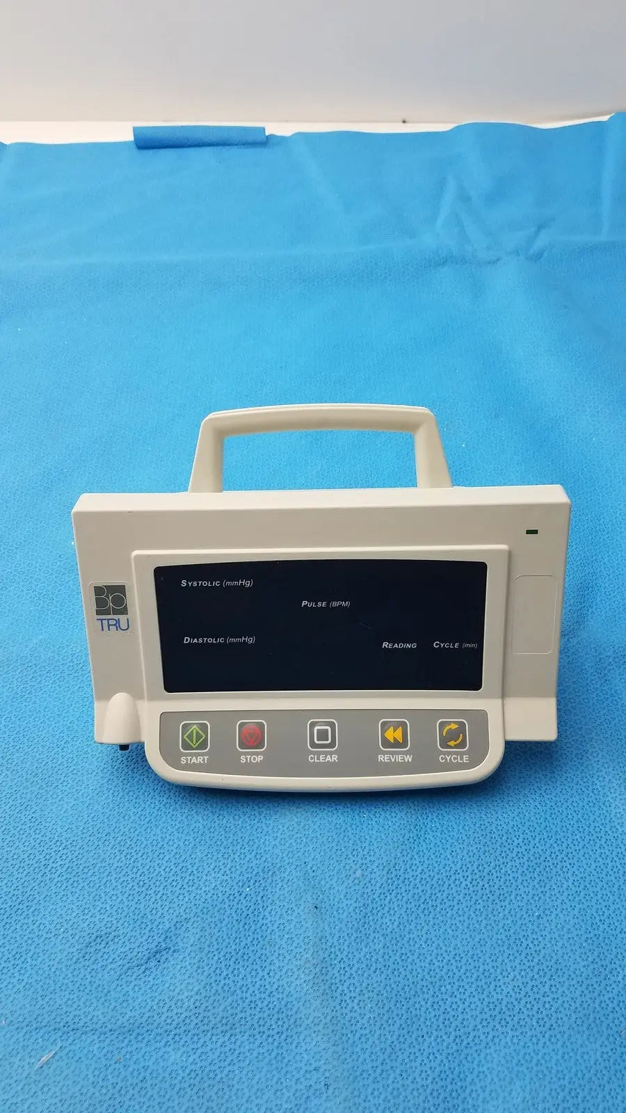 White plastic automatic blood pressure monitor infusion pump with black digital display and labeled buttons