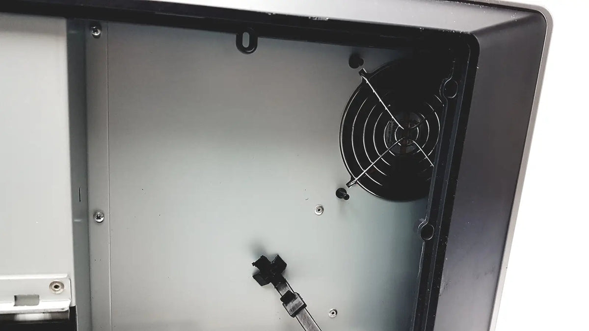 Black circular fan with protective grille inside open computer case of barco mdcc-6230 color led general radiology display