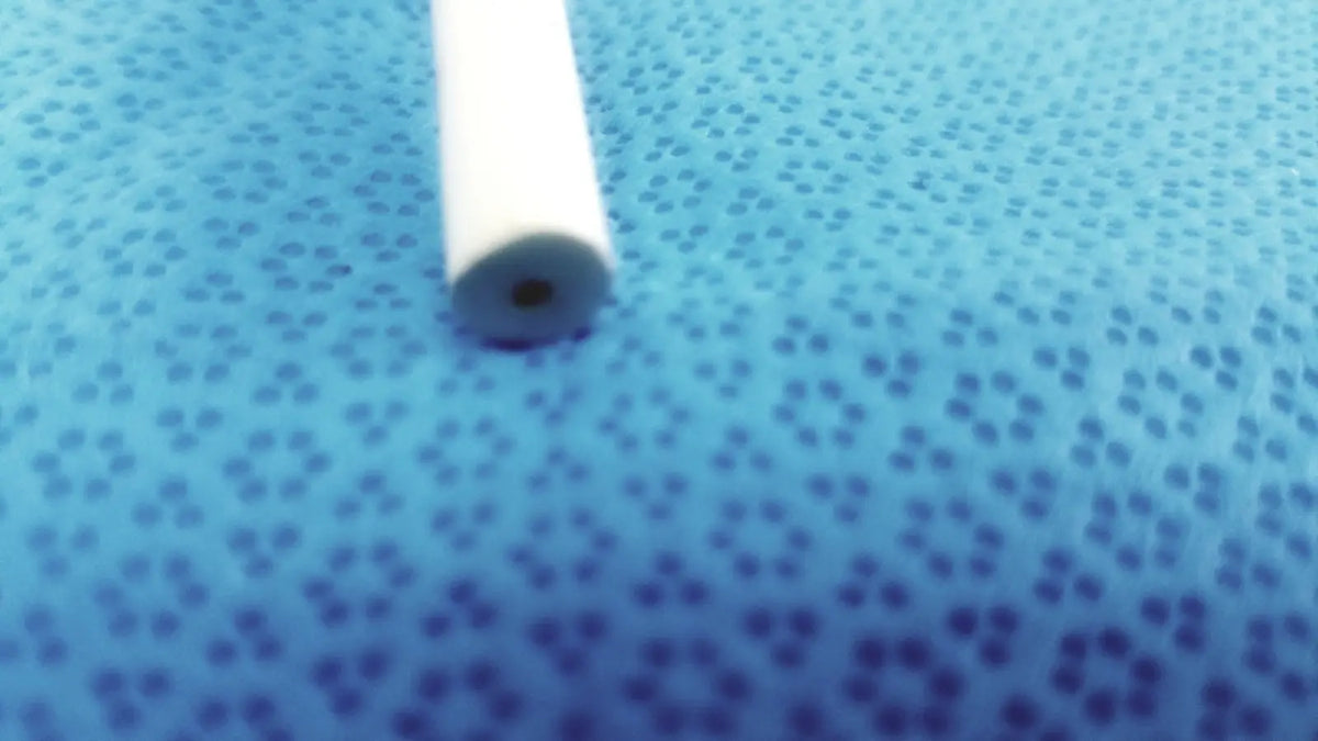 White cylindrical bard 21fr maloney tapered tungsten-filled esophageal bougie with small hole on blue surface