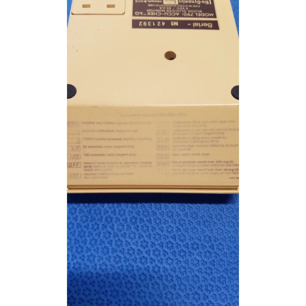 Beige plastic bio-dynamics accu-chek bg 90 blood glucose monitor showing printed labels and serial number