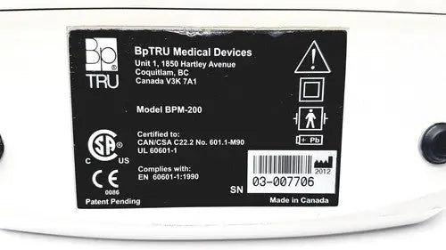 White bp tru bpm-200 automatic blood pressure monitor showing black label with certification and serial number details