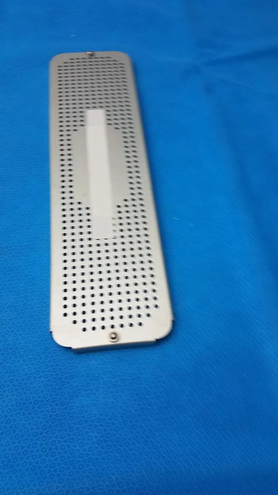 Silver metallic rectangular case medical ENCM sterilization container box lid with circular ventilation holes and screws