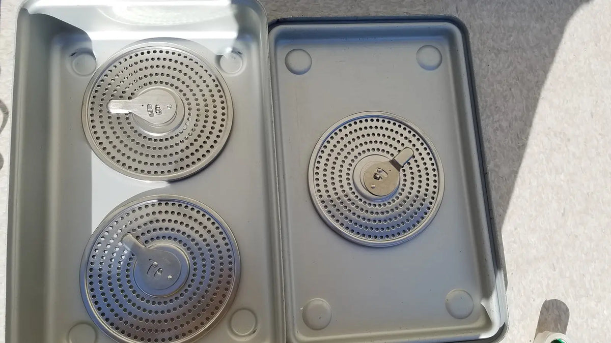 Silver circular gas burner grates with perforated surfaces and control knobs in case medical karl storz ks z-39311as container