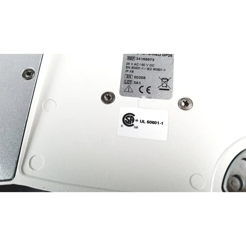 White plastic backplate of cellvizio foot pedal with silver screws and regulatory compliance labels visible