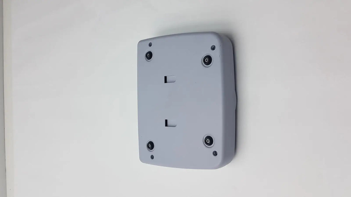 Gray rectangular control panel for titmus i400 vision screener with four black circular screws mounted on wall