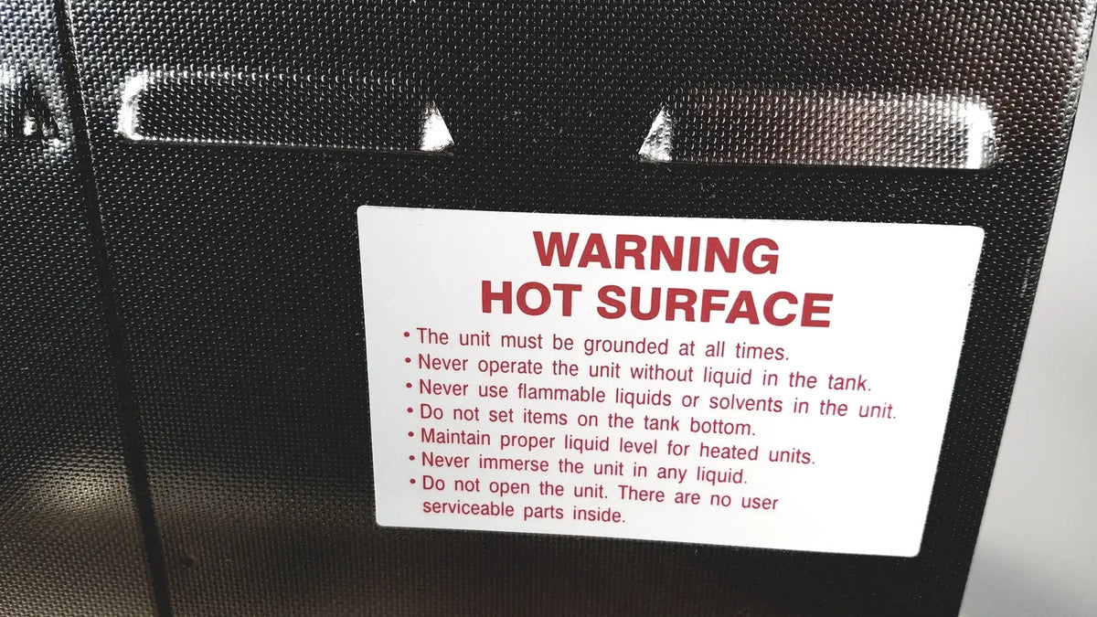 Black textured surface with white warning label and red text warning hot surface on crest ultrasonic powersonic cleaner model p1100d