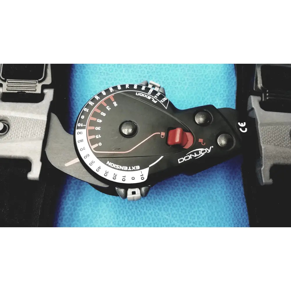 Black donjoy extension dial with red indicator and white numerical markings on rom adjustable arm brace for flexion and extension support
