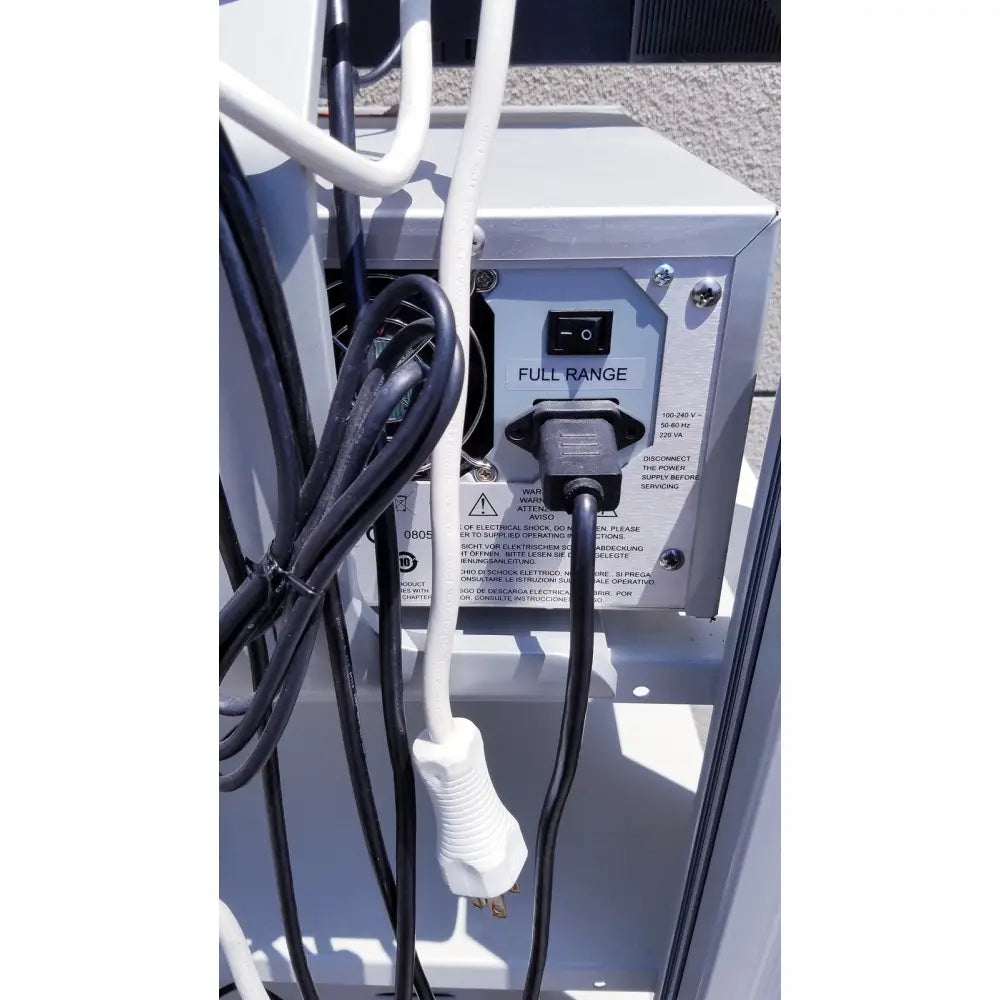 Black electrical plug connected to white power cord on the back panel of gray ellex eyecubed ultrasound biomicroscopy system