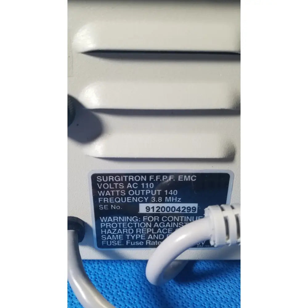 White plastic ellman surgitron emc electrosurgical unit instrument labeled with serial number and technical specifications