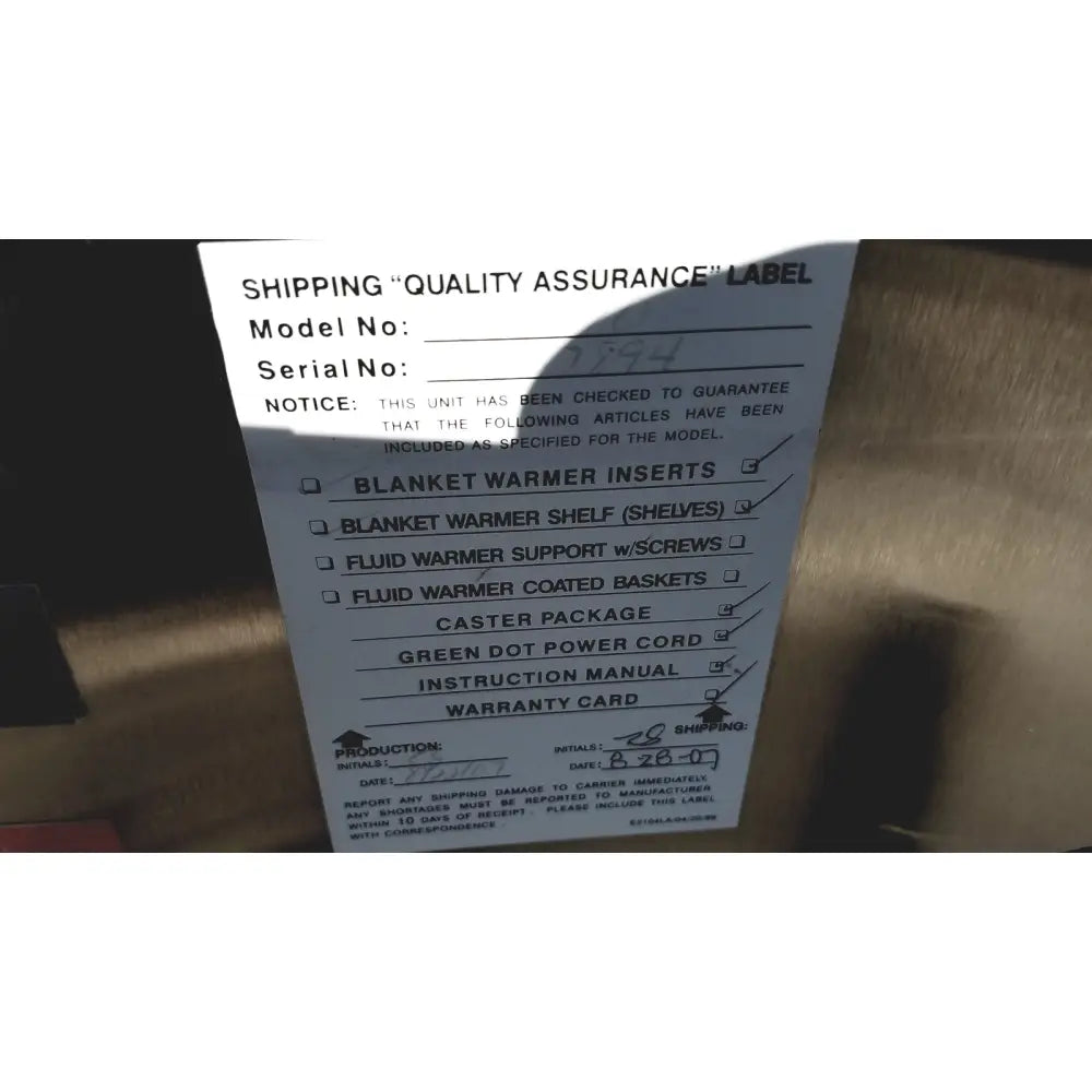 White paper label with model number serial number checklist and production date on the back of enthermics medical systems ec770 fluid warmer