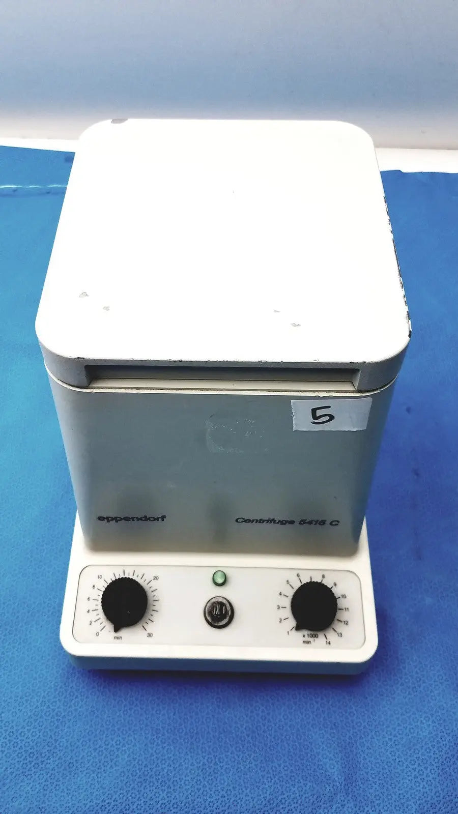White and gray eppendorf centrifuge laboratory centrifuge model w250 with black knobs and green power indicator light