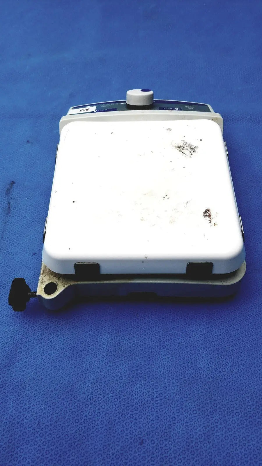 White rectangular fisher scientific isotemp digital hotplate with blue control panel and black knob showing wear
