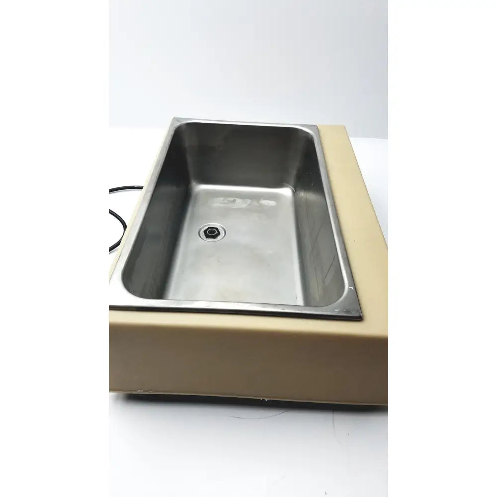 Stainless steel rectangular sink set into beige plastic base of fisher scientific versa-bath model 139 heated water bath