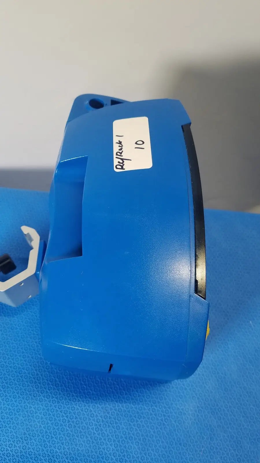 Blue plastic component with white refrack 10 label on the side of ge healthcare v180-jbac-axaa-xx vital signs monitor
