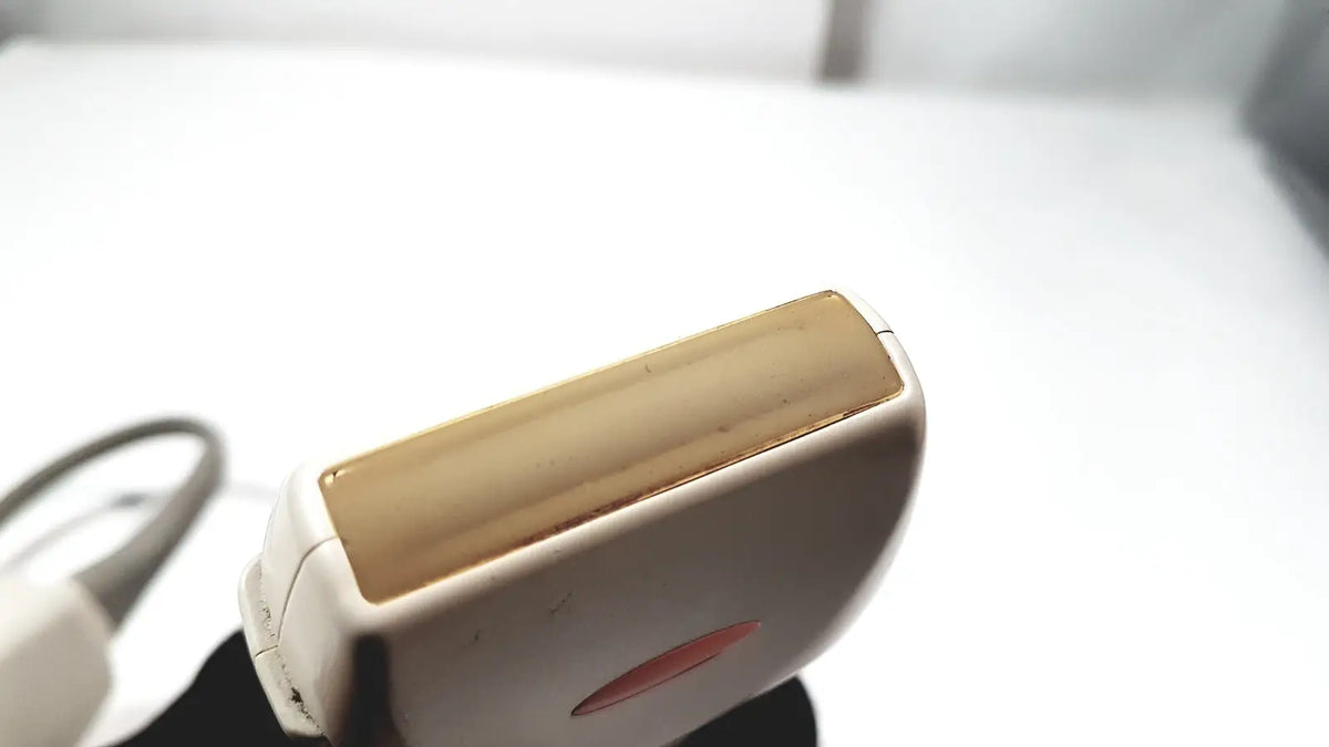 White and gold electric epilator with sleek ergonomic design featured alongside ge medical systems ultrasound convex array transducer