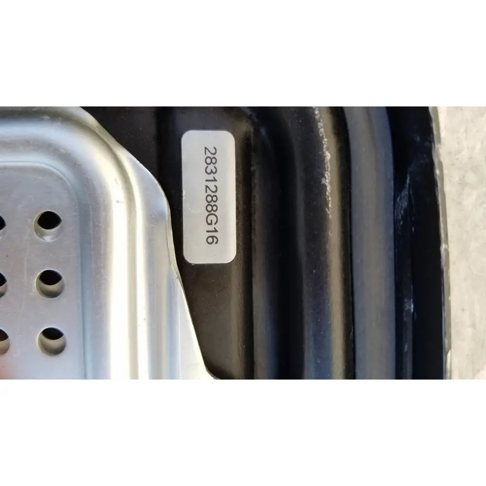A white alphanumeric sticker on the black genesis sterilization container half lid affixed to a dark curved surface