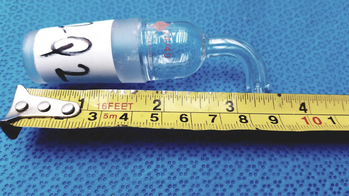 Clear glass laboratory bulb with curved neck and white label marked 20 in glass adapter for straight connection to rubber tubing