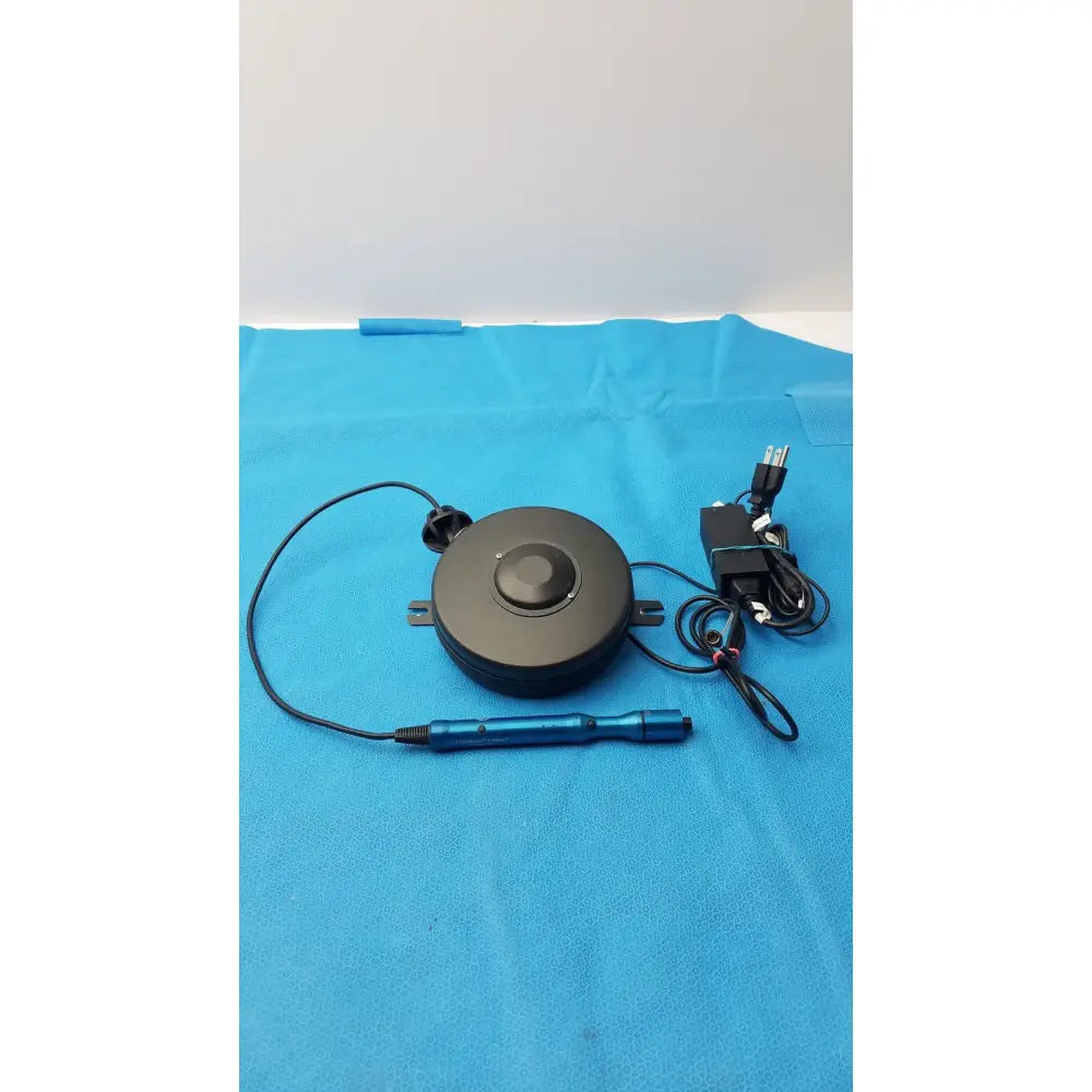 Black circular cable pull reel with blue handle and power cord for globalmedia totalexam s-video examination camera
