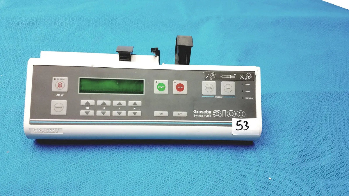 White graseby 3100 syringe delivery device with green digital display and gray control panel on blue surface device clean medical unit