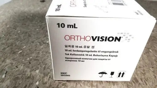 White cardboard box for orthovision 10 ml eye drop solution displayed with grifols cards and dilution trays for reuse medical applications