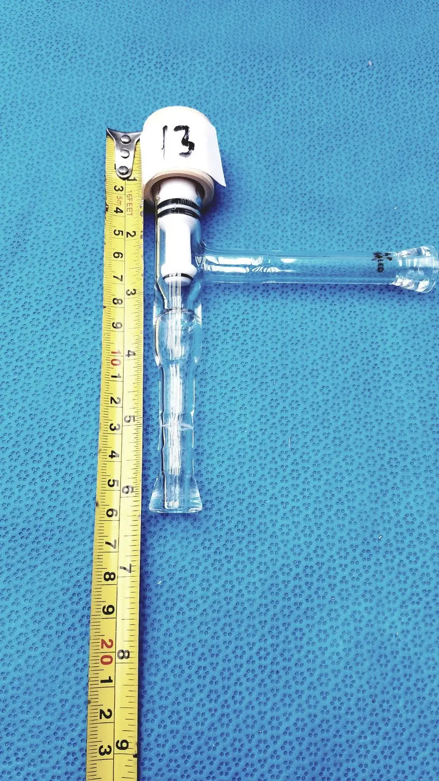 Clear plastic endotracheal tube with white numbered cuff shown with high vacuum lab glass valve teflon coated and durable