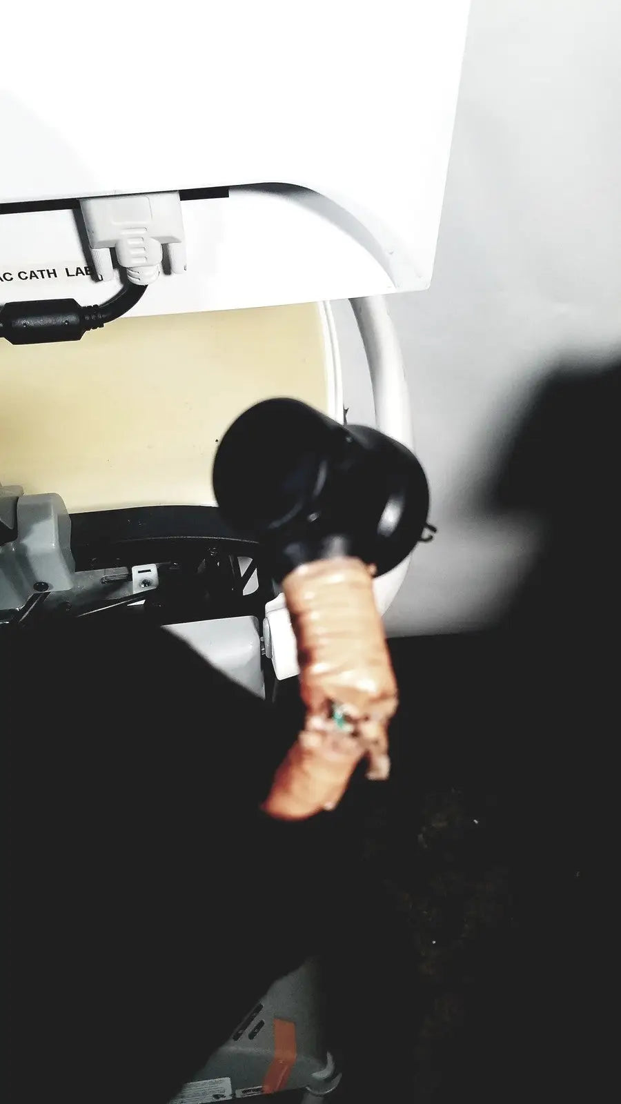 Black cylindrical robotic arm with copper wiring on the lower section of howard medical hi-care monitor stand